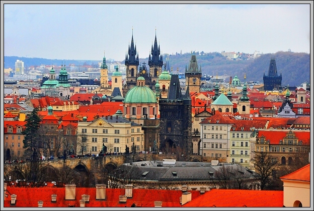 Věže Týnského chrámu nad červenými střechami Starého Města