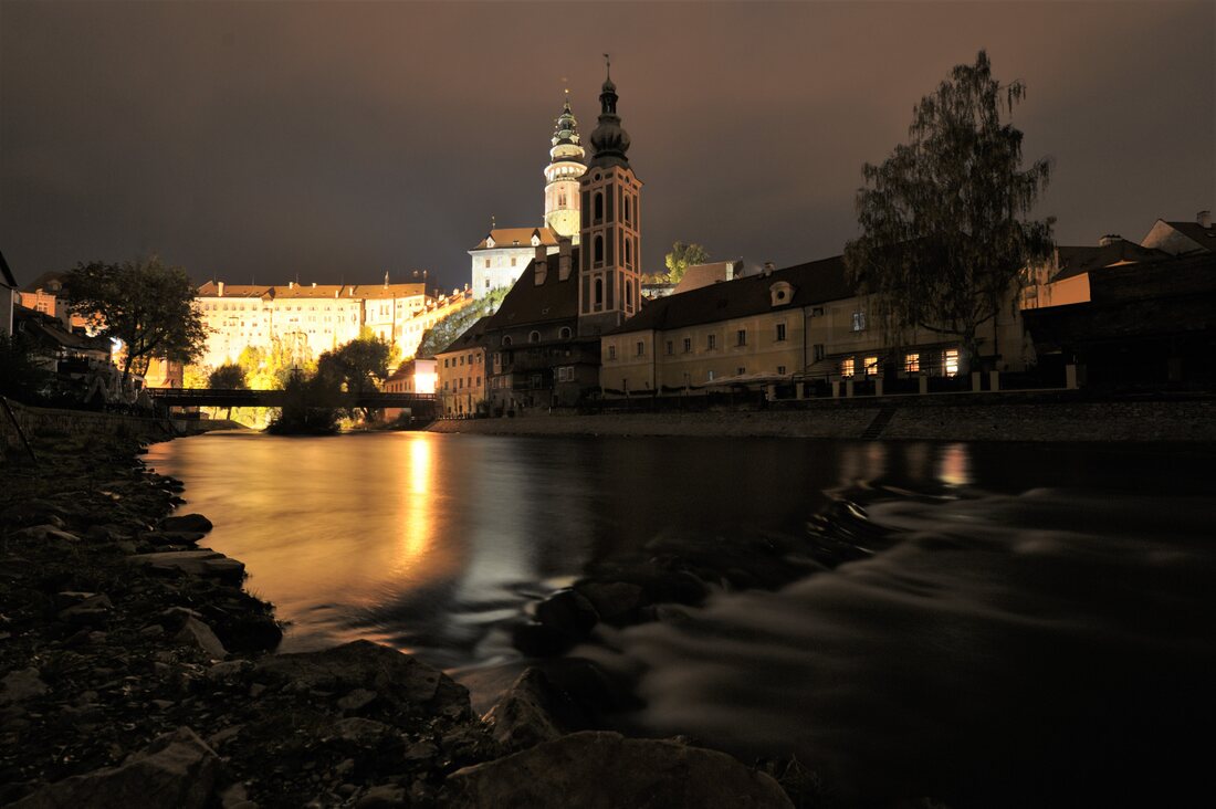 Věže Českého Krumlova nad hladinou Vltavy za noci